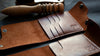 MZ Leather Craft el yapımı Dil Kapaklı Cüzdan modelleri; el dikimi kart bölmeleri, damgalı logo detayı ve arka planda net bir şekilde görünen ahşap perdah (kenar parlatma) aleti.