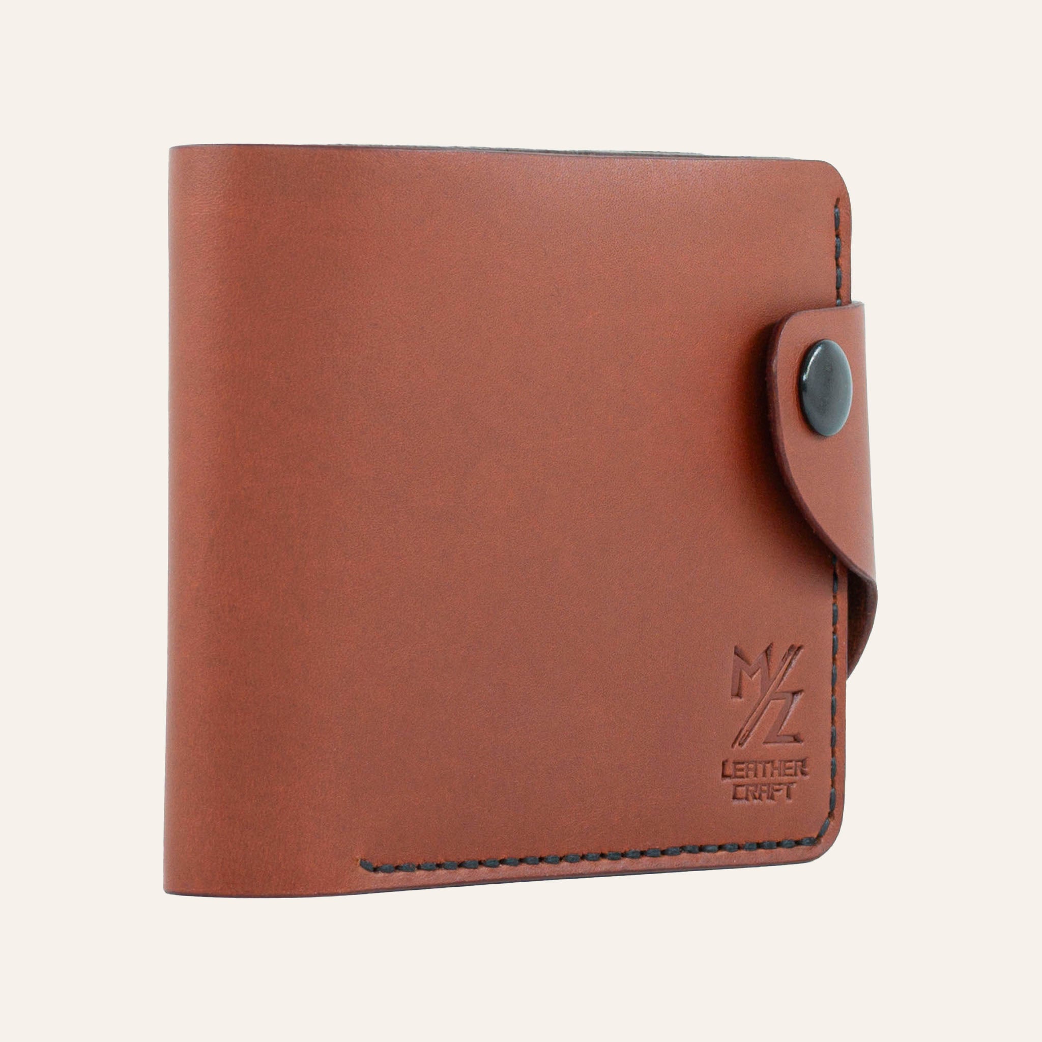 MZ Leather Craft hafif açılı kiremit Buttero deri klasik erkek cüzdanı, kapalı duruş ve kontrast siyah el dikişi detayları | MZ Leather Craft slightly angled Chestnut Buttero leather classic bifold wallet, closed position showing edge structure and black hand-stitching details