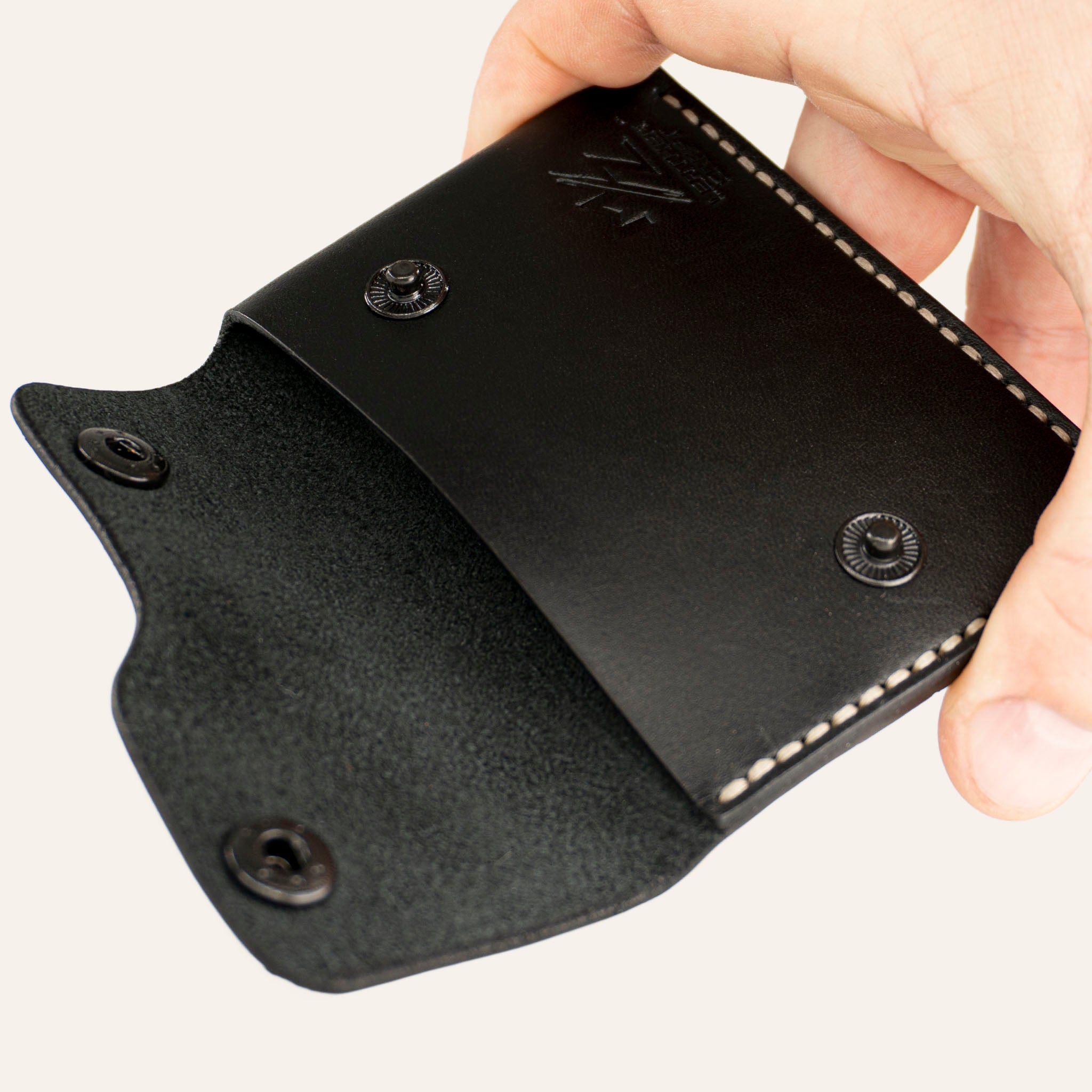 MZ Leather Craft açık kapaklı minimalist siyah Buttero deri cüzdan, el ile tutulan iç görünüm, ana bölme, açık çıtçıtlar ve açık gri el dikişi detayları | Minimalist Snap-Flap Leather Wallet - Black Buttero Leather by MZ Leather Craft open view held by hand, showing the main compartment, open snaps, and light gray hand-stitching details