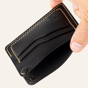 MZ Leather Craft köşe çıtçıtlı ters cüzdan siyah Buttero deri, el ile tutulan açık köşe çıtçıtlı görünüm, iç bölme ve işlevsel tasarım sunumu | The Inverse Wallet | Corner Snap Edition - Black Buttero Leather by MZ Leather Craft, open view held by hand showing the unfastened corner snap, inner compartment, and functional design