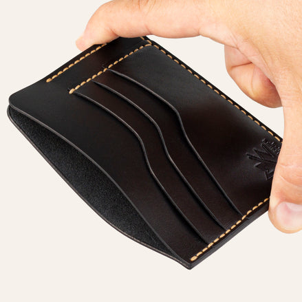 MZ Leather Craft siyah Buttero deri ters cüzdan, el ile tutulan hafif açılı boş görünüm, ana bölmeyi ve sarı saraç dikişi detaylarını gösteren açı | The Inverse Wallet - Black Buttero Leather by MZ Leather Craft, empty view held by hand at a slight angle, showcasing the main compartment and yellow saddle-stitching details