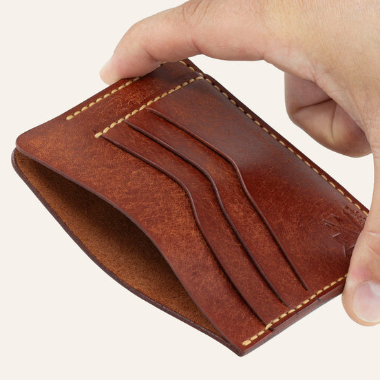 MZ Leather Craft kiremit Pueblo deri ters cüzdan, el ile tutulan hafif açılı boş görünüm, ana bölmeyi ve sarı saraç dikişi detaylarını gösteren açı | The Inverse Wallet - Siena Pueblo Leather by MZ Leather Craft, empty view held by hand at a slight angle, showcasing the main compartment and yellow saddle-stitching details