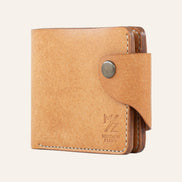 MZ Leather Craft natürel Pueblo deri klasik cüzdan, yandan kapalı duruş ve açık gri el dikişi detayları, sağlam çıtçıtlı kapama dili ile | MZ Leather Craft cognac Pueblo leather classic bifold wallet, side profile view of closed wallet with light gray hand-stitching details and secure snap closure strap