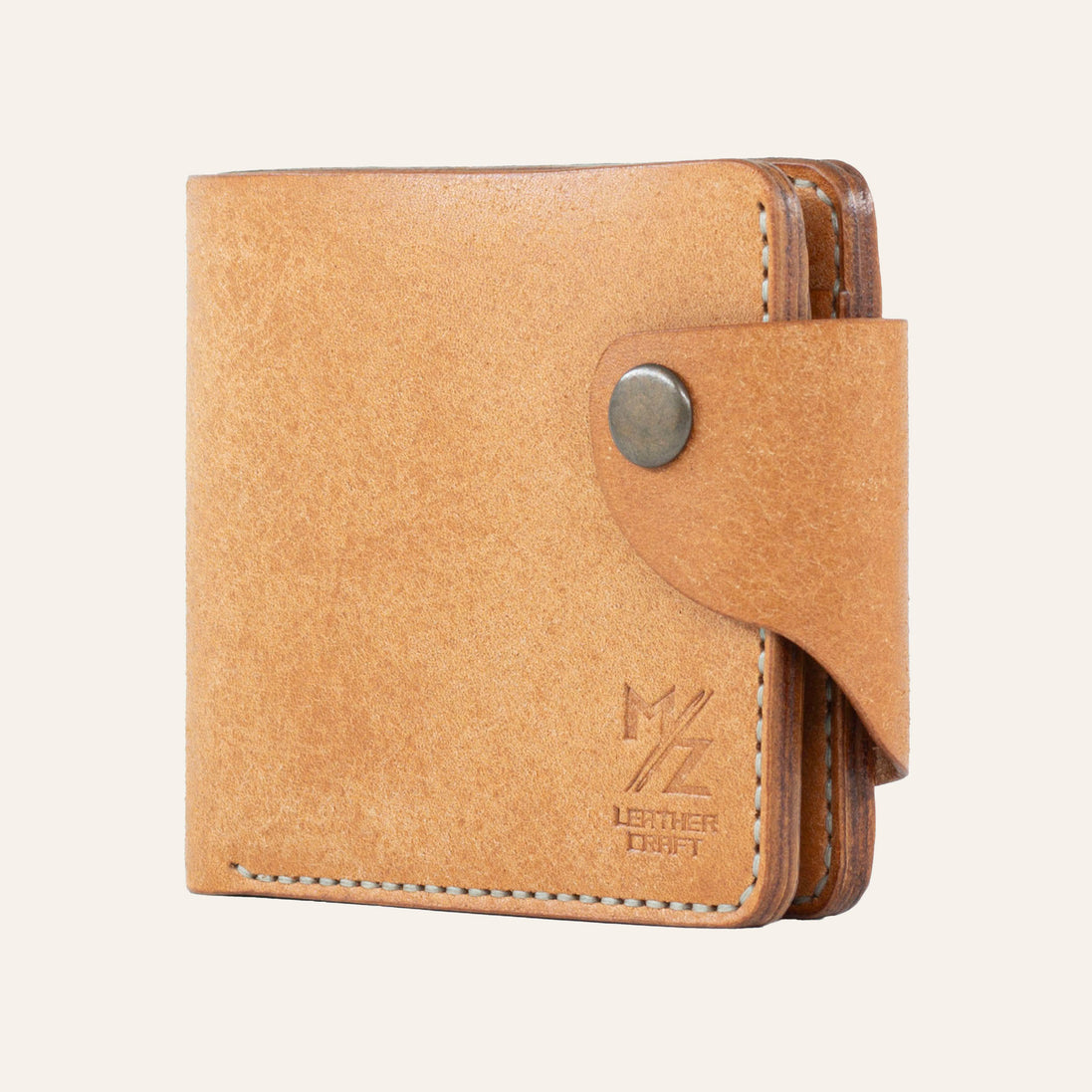 MZ Leather Craft natürel Pueblo deri klasik cüzdan, yandan kapalı duruş ve açık gri el dikişi detayları, sağlam çıtçıtlı kapama dili ile | MZ Leather Craft cognac Pueblo leather classic bifold wallet, side profile view of closed wallet with light gray hand-stitching details and secure snap closure strap