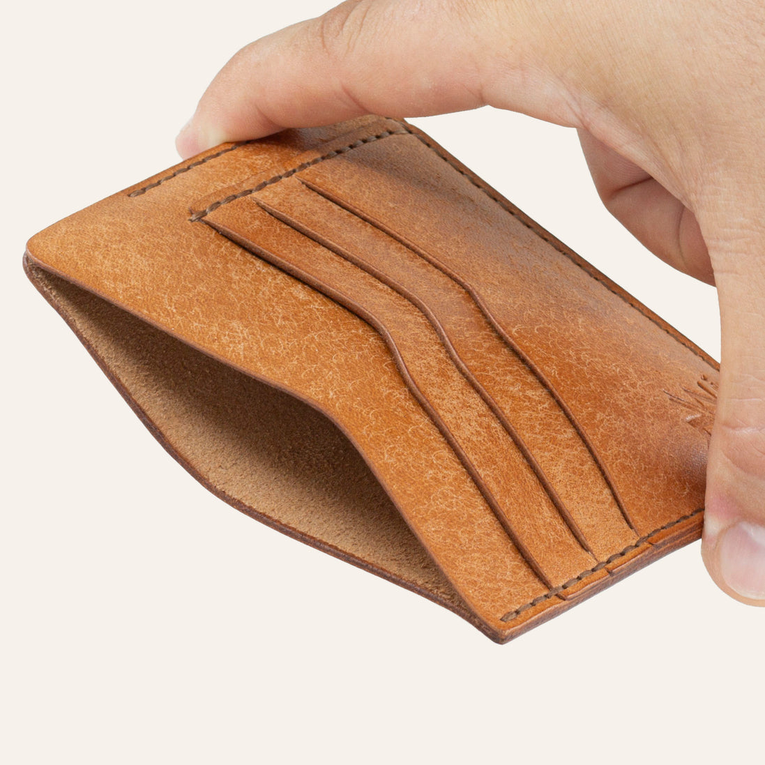 MZ Leather Craft natürel Pueblo deri ters cüzdan, el ile tutulan hafif açılı boş görünüm, ana bölmeyi ve kahverengi saraç dikişi detaylarını gösteren açı | The Inverse Wallet - Cognac Pueblo Leather by MZ Leather Craft, empty view held by hand at a slight angle, showcasing the main compartment and brown saddle-stitching details