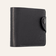 MZ Leather Craft hafif açılı siyah Pueblo deri klasik erkek cüzdanı, kapalı duruş ve kontrast gri el dikişi detayları | MZ Leather Craft slightly angled black Pueblo leather classic bifold wallet, closed position showing edge structure and gray hand-stitching details