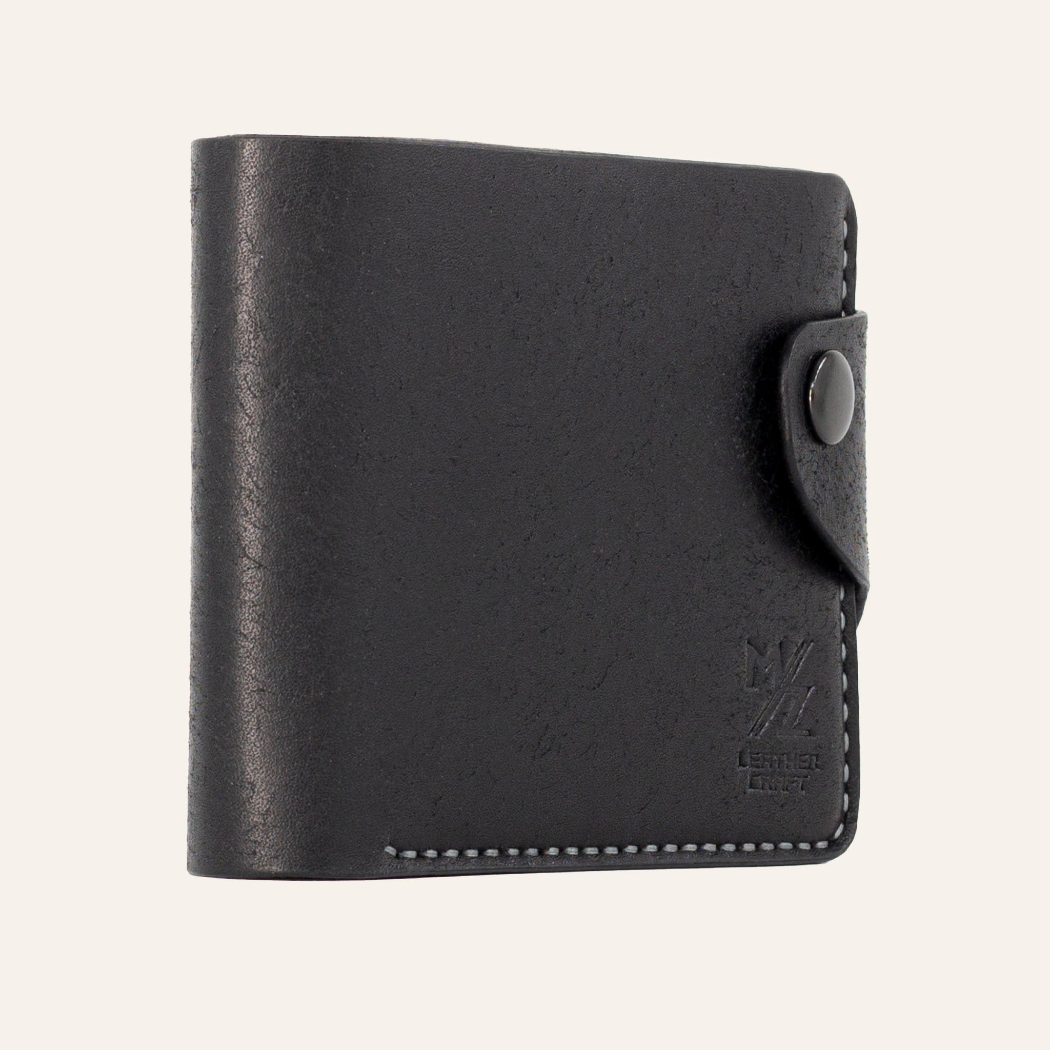 MZ Leather Craft hafif açılı siyah Pueblo deri klasik erkek cüzdanı, kapalı duruş ve kontrast gri el dikişi detayları | MZ Leather Craft slightly angled black Pueblo leather classic bifold wallet, closed position showing edge structure and gray hand-stitching details