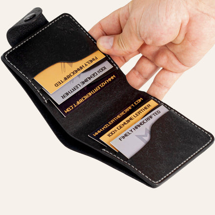 MZ Leather Craft açık siyah Pueblo deri yatay cüzdan, 6 kart bölmesi ve el ile sunum. Kartlar üzerindeki profesyonel gravür metinler ve MZ logosu net. | Open black Pueblo leather horizontal bifold wallet by MZ Leather Craft presented by hand with professionally engraved texts and MZ logo.