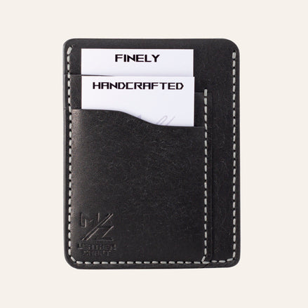 MZ Leather Craft dikey minimalist siyah Pueblo deri kartlık, kartlarla dolu önden görünüm, gri el dikişleri ve sol alt köşede kabartmalı MZ logosu | The Vertical Minimalist Cardholder - Black Pueblo Leather by MZ Leather Craft, front view filled with cards, featuring gray hand-stitching and an embossed MZ logo on the bottom left corner