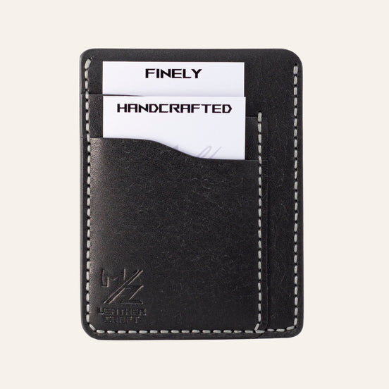 MZ Leather Craft dikey minimalist siyah Pueblo deri kartlık, kartlarla dolu önden görünüm, gri el dikişleri ve sol alt köşede kabartmalı MZ logosu | The Vertical Minimalist Cardholder - Black Pueblo Leather by MZ Leather Craft, front view filled with cards, featuring gray hand-stitching and an embossed MZ logo on the bottom left corner